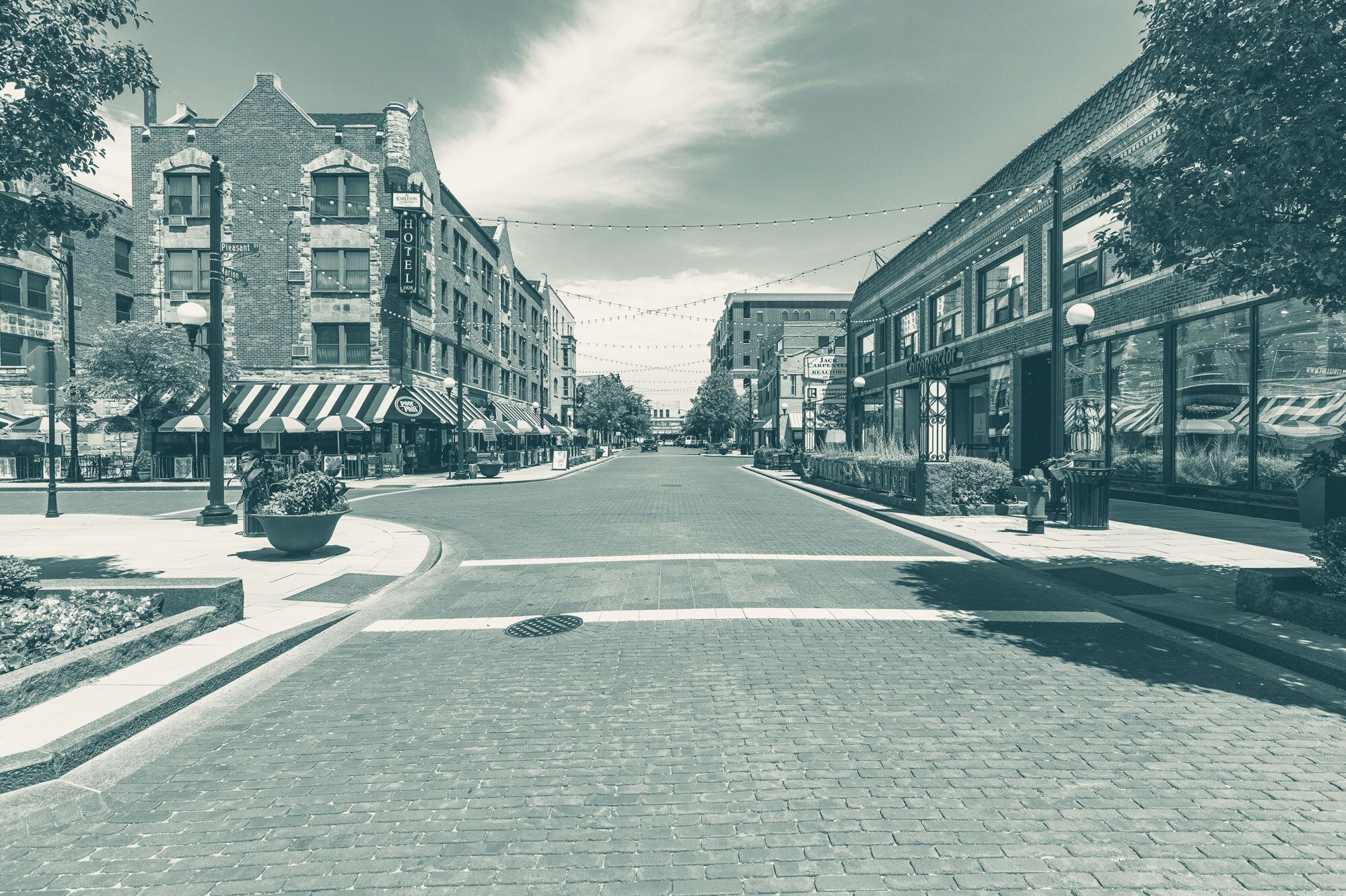 A brick road with low-rise buildings on the sides